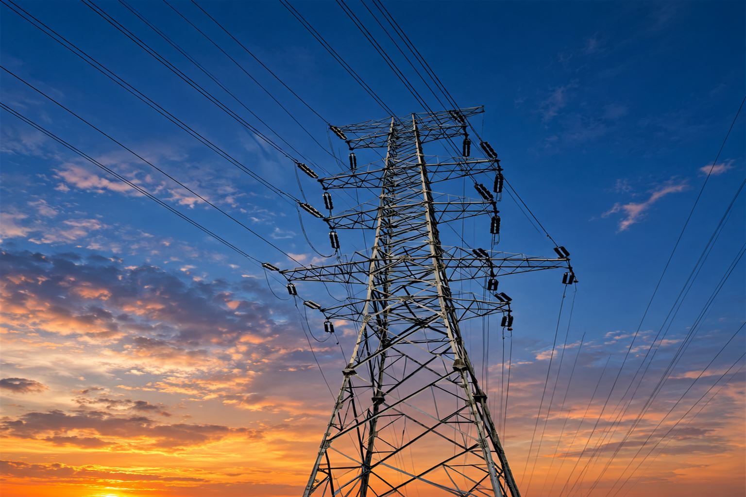 High-voltage transmission tower at sunset